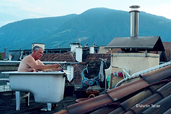 Mann in Badewanne auf einem Hausdach