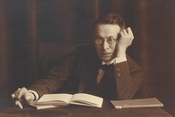 Porträt eines Mannes am Schreibtisch sitzend, vor einem Buch